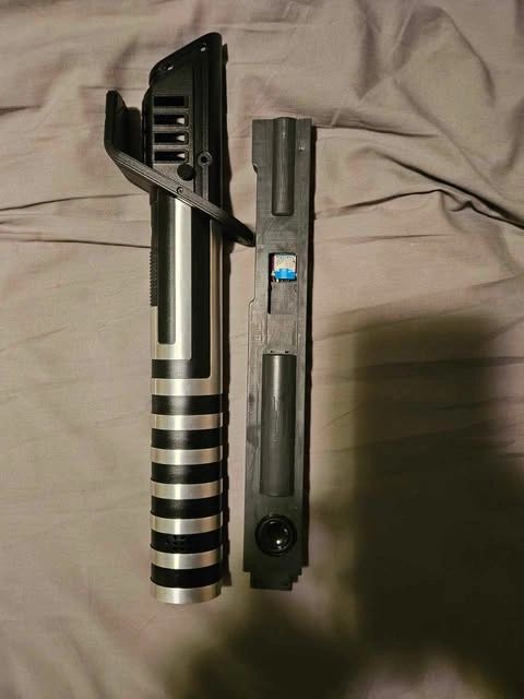 Two parts of a disassembled firearm laid on a fabric surface.